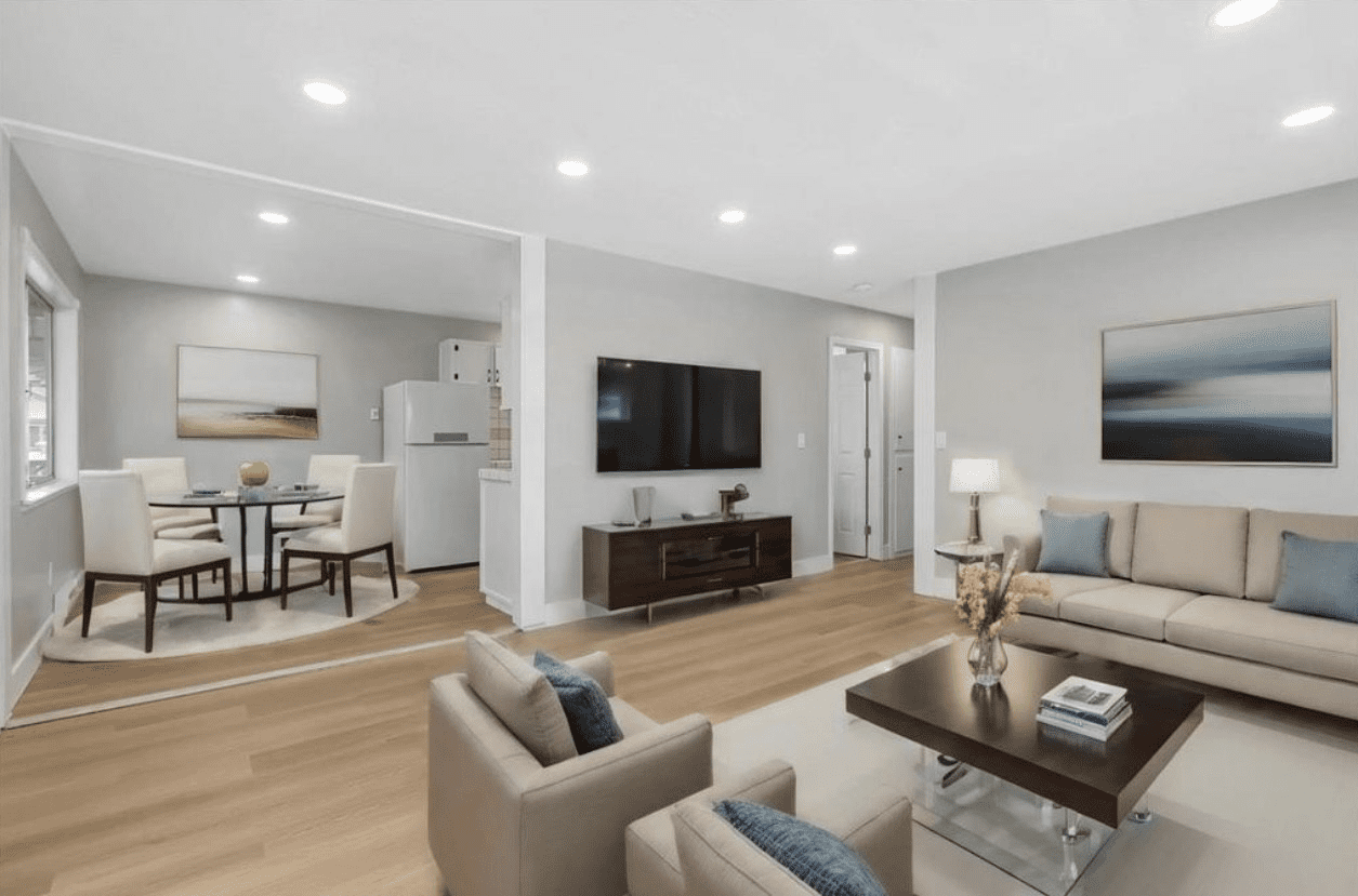 A living room with couches, tables and a television.